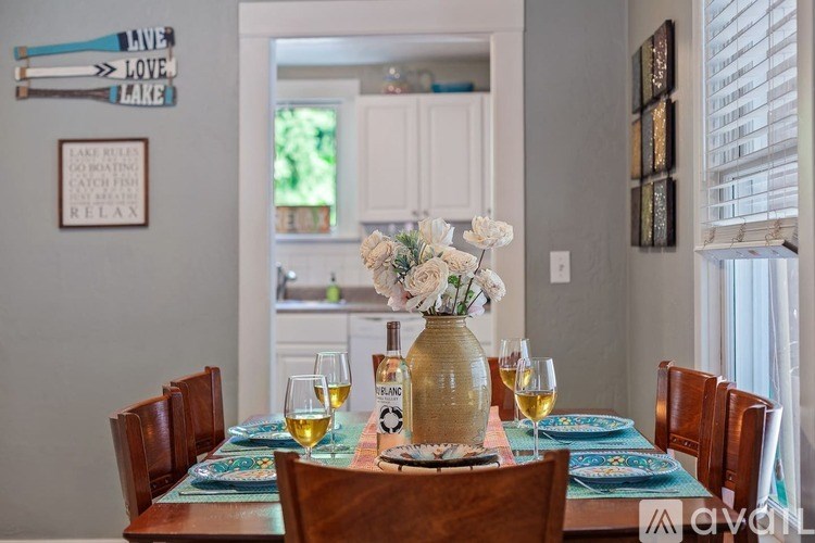 A dining table set with plates and glasses of wine.