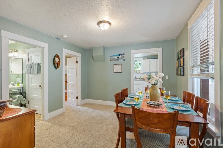 A dining room with a table set for a meal.