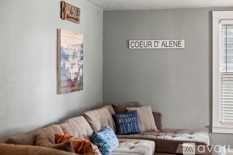 A living room with a couch and a sign that says "COEUR D'ALENE".