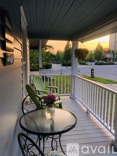 A balcony with a table and chairs overlooking a street.