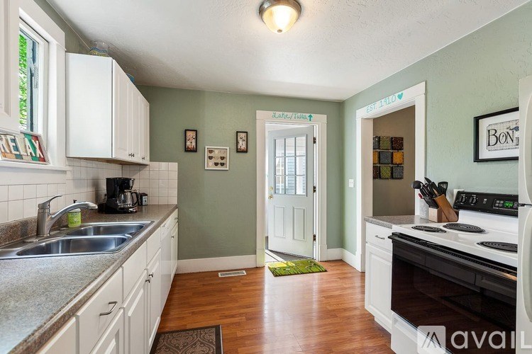A kitchen with white cabinets and a black stove top oven.
