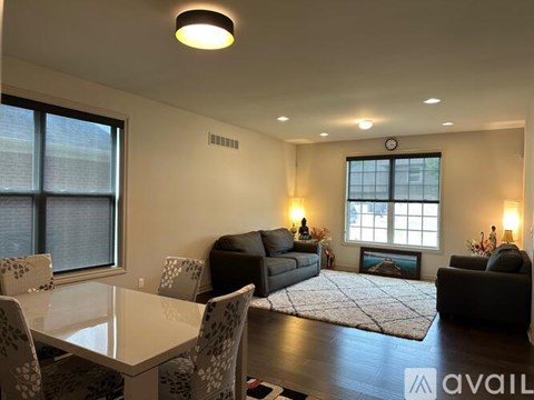 A living room with a couch, chairs, and a table.