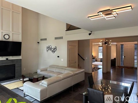 A living room with a white couch and a fireplace.