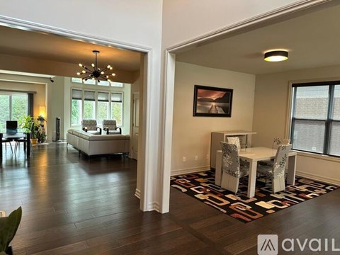 A living room with a white sofa and a dining table with chairs.