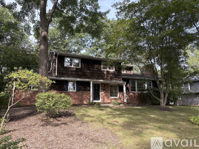 A house with a brown roof and a flag on the front porch.