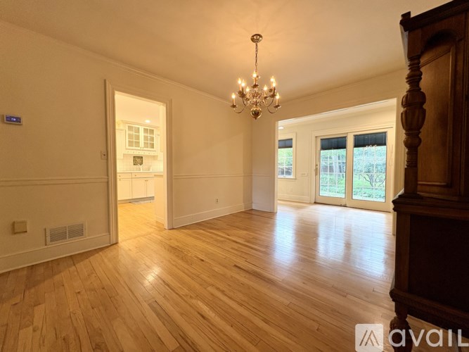 A room with wooden floors and a chandelier.