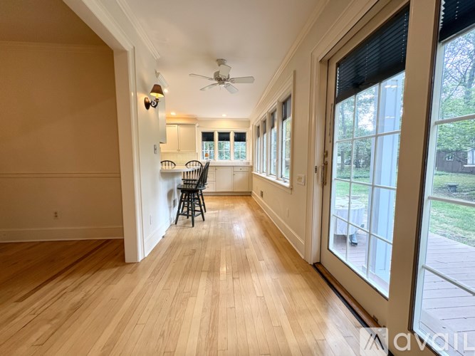 A long hallway with a chair and a fan.