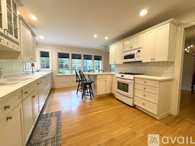 A kitchen with wooden floors and white cabinets.