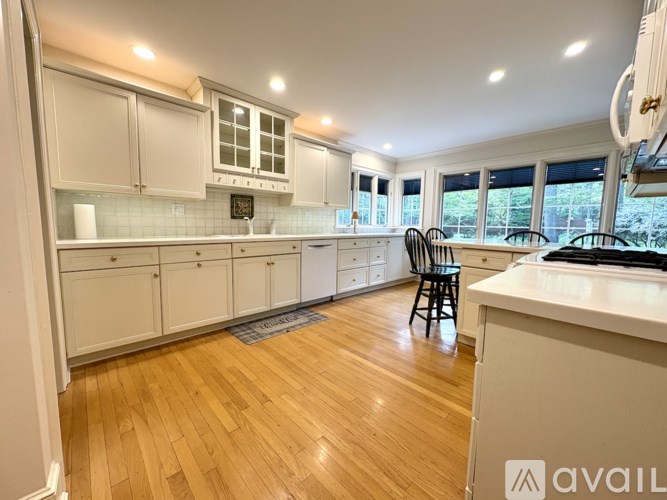 A kitchen with white cabinets and a wooden floor.