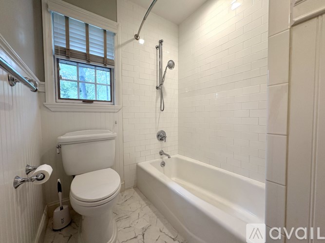 A white toilet is next to a bathtub in a bathroom.