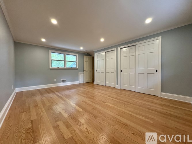 A room with wooden flooring and white walls.