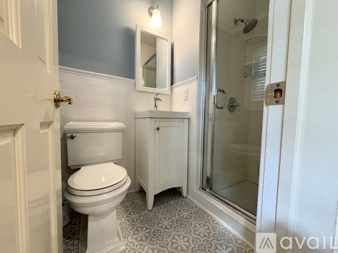 A bathroom with a toilet, sink, and shower.