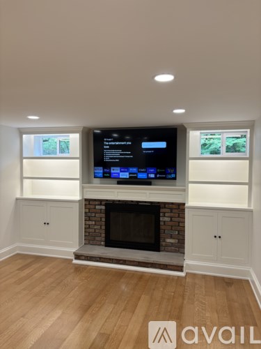 A modern living room with a brick fireplace and a flat screen TV mounted above it.