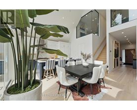 A modern dining room with a large table and chairs.