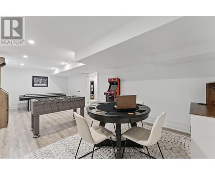 A room with a pool table, a dining table and chairs, and a foosball table.