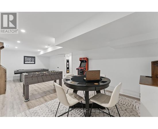 A room with a pool table, a dining table and chairs, and a foosball table.