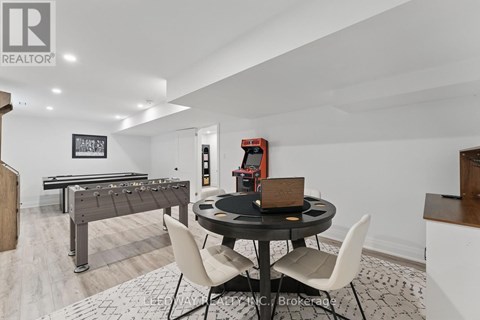 A room with a pool table, a dining table and chairs, and a foosball table.
