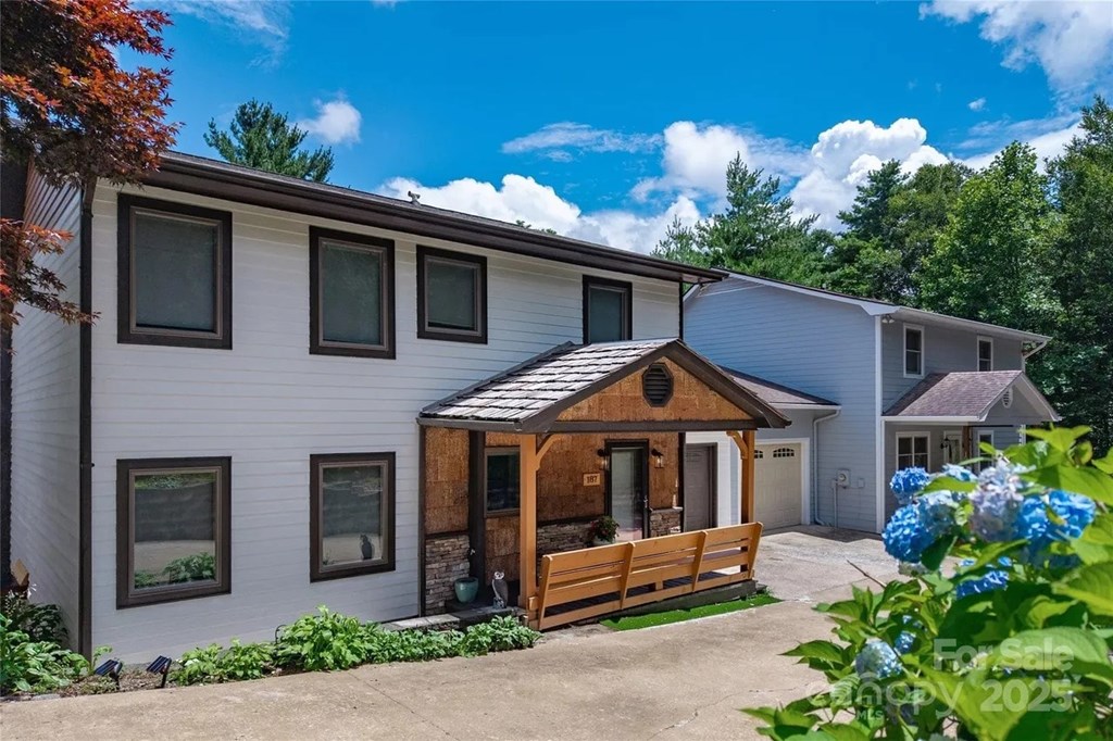 A white house with a brown door and windows.