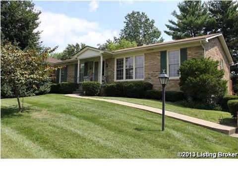A house with a green lawn and a lamp post in front.