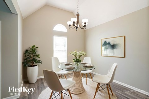 A dining room with a glass table and chairs.