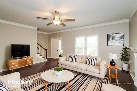 A living room with a white couch and a flat screen TV.