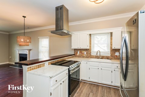 A kitchen with a stove top oven and a refrigerator.