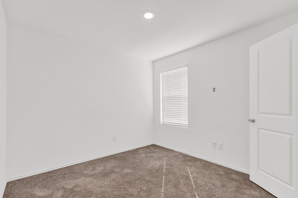 A room with a carpeted floor and a door.