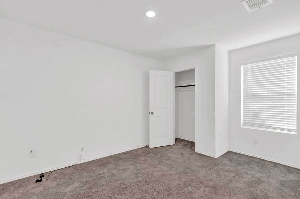 A room with a white door and carpeted floor.
