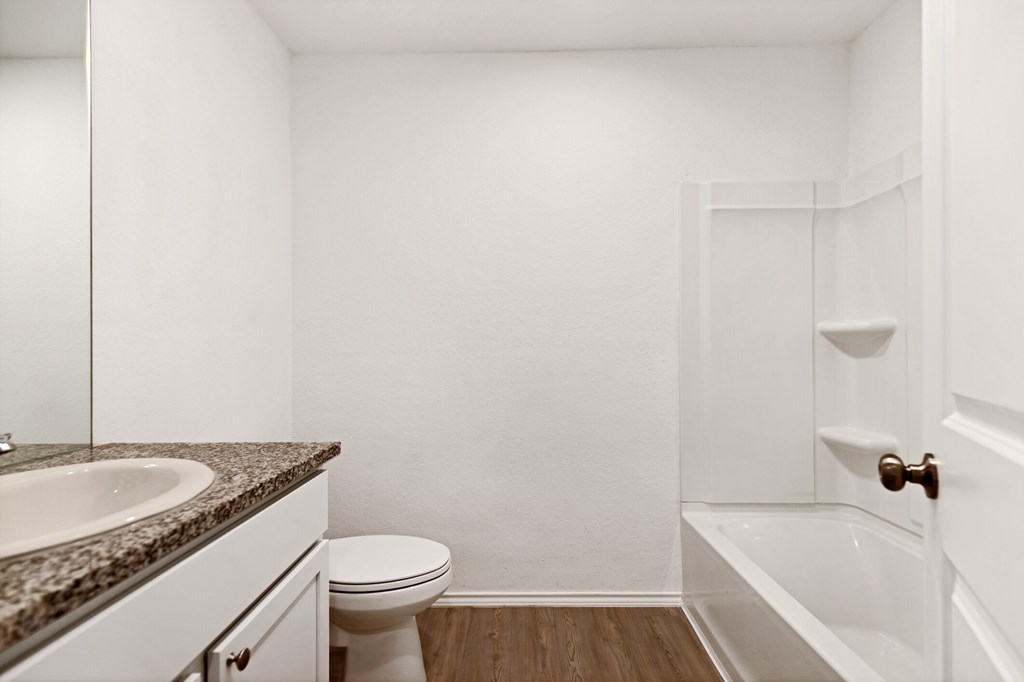 A white bathroom with a toilet, sink, and bathtub.