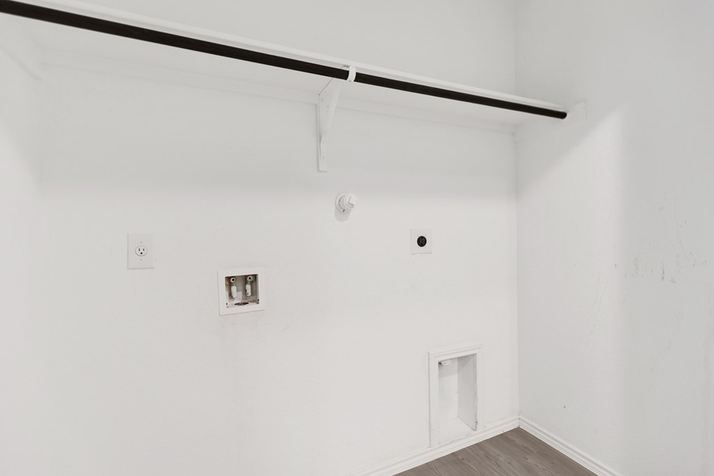 A white room with a black bar on the ceiling and a small window.