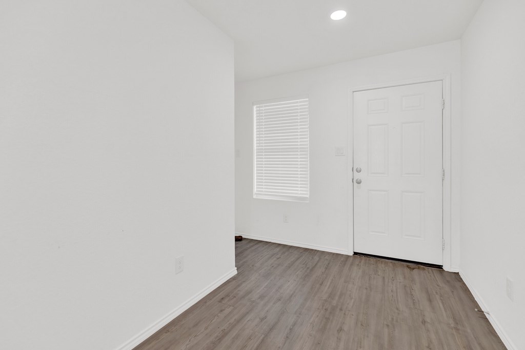 A room with a white door and a window with blinds.