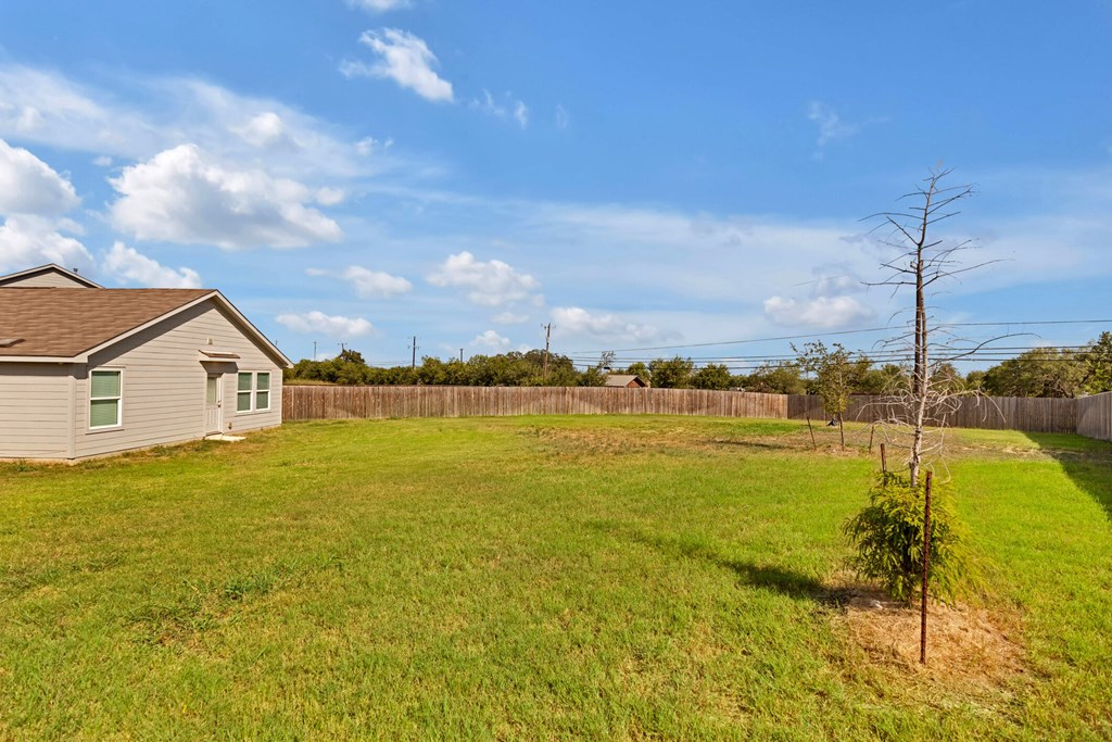 A small house with a green lawn in front of it.