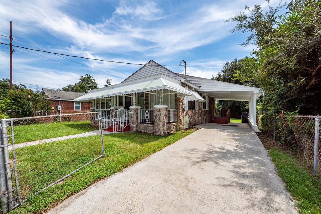 A house with a white fence and a green lawn.