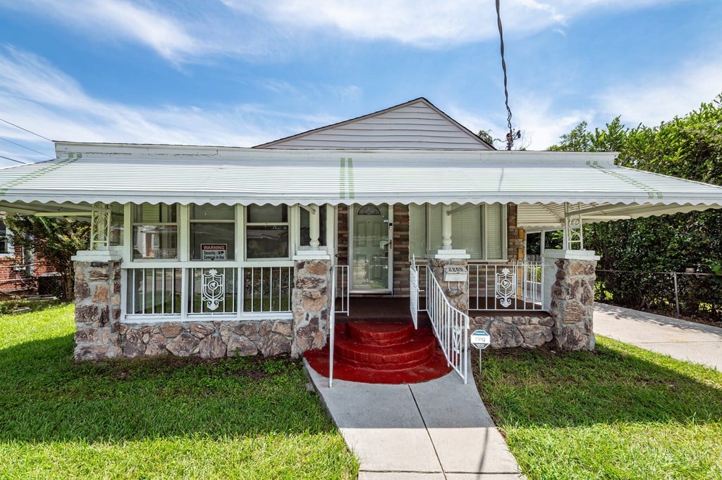 A house with a red carpeted entrance and a white porch.