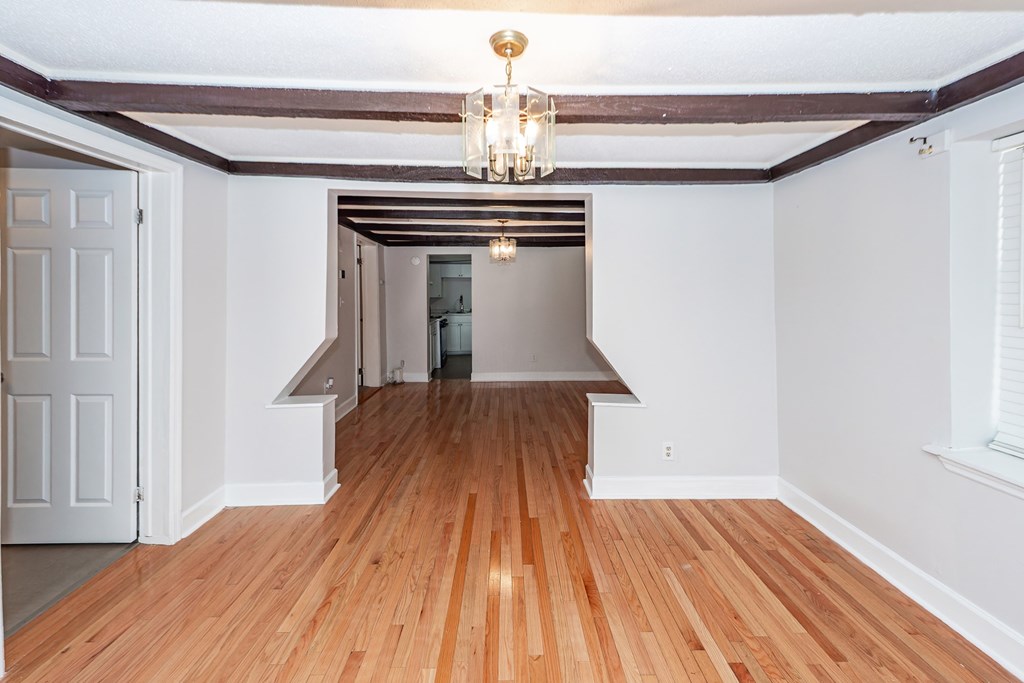 A room with wooden floors and a chandelier.