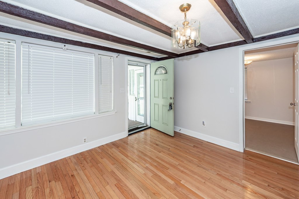 A room with wooden floors and a green door.
