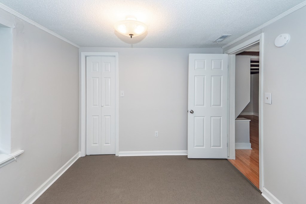 A room with two white doors and a carpeted floor.