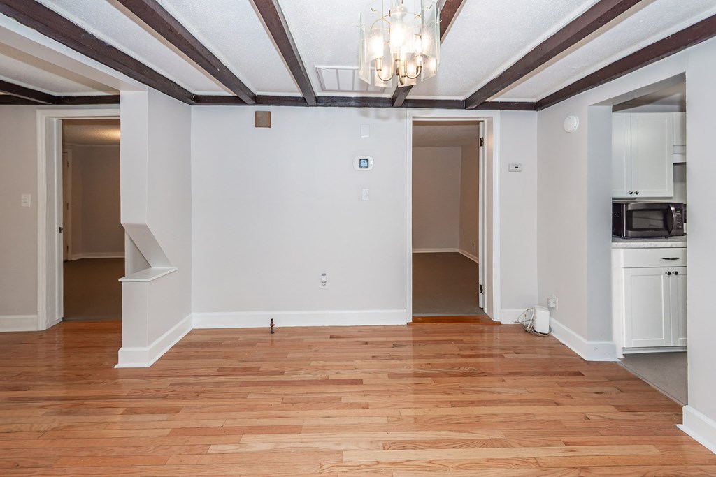 A room with wooden floors and a chandelier.