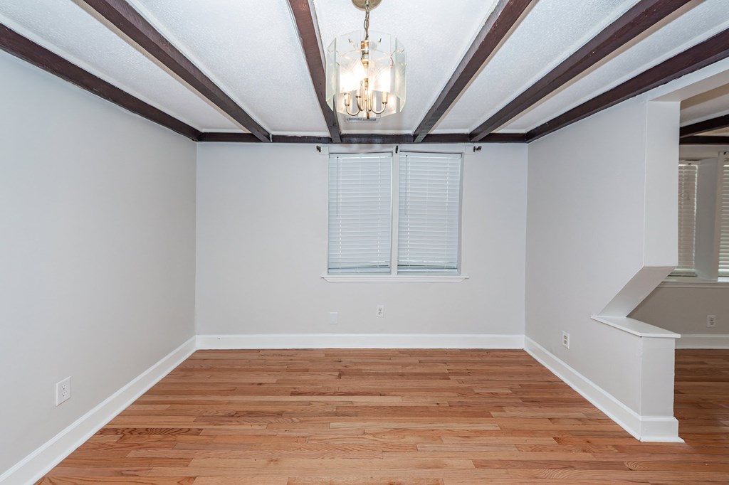 A room with wooden floors and a chandelier.