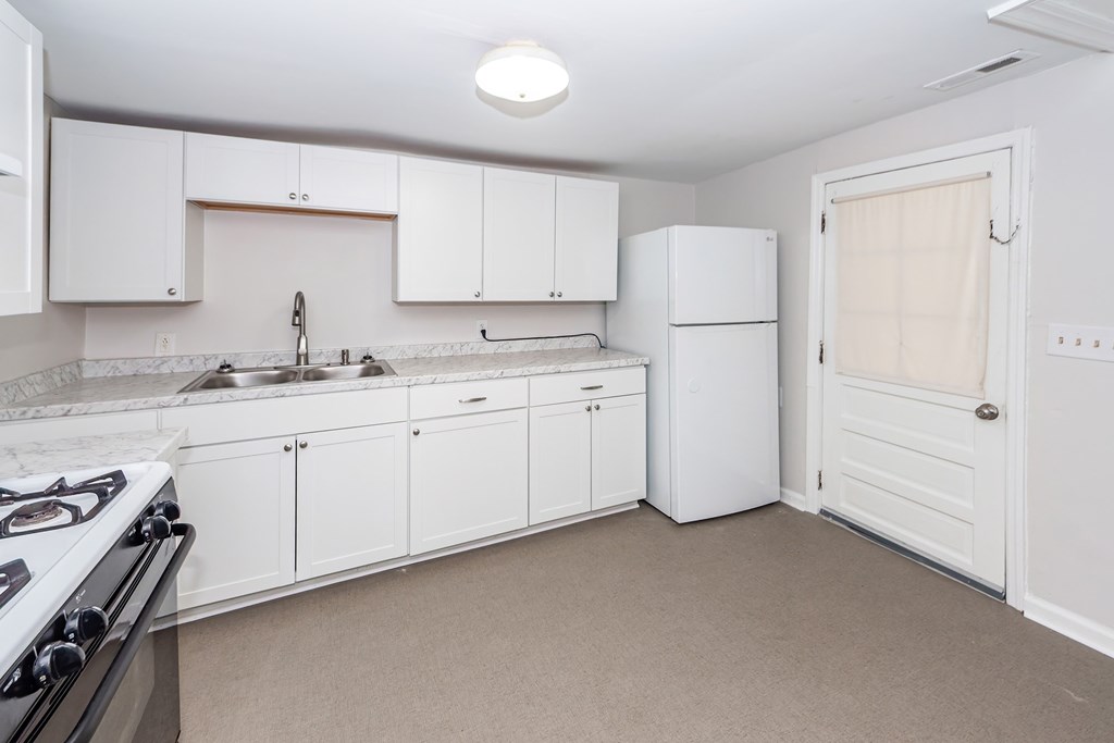 A kitchen with white cabinets and a black stove top.