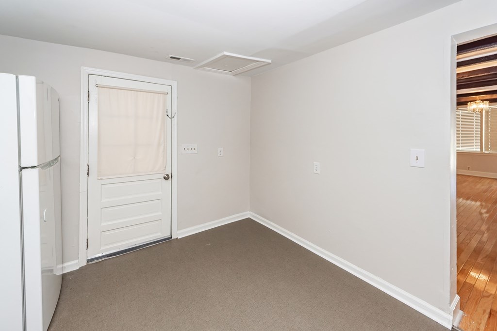A white door with a white frame is in a room with white walls.