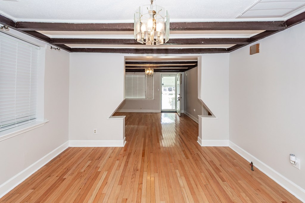 A room with wooden floors and a chandelier.