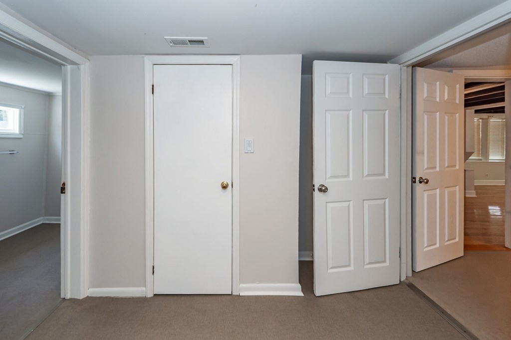 A white door is in the middle of two other white doors.