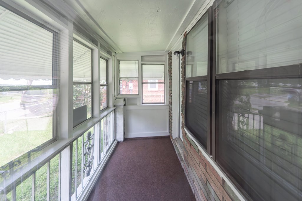 A long hallway with a red carpet and white walls.