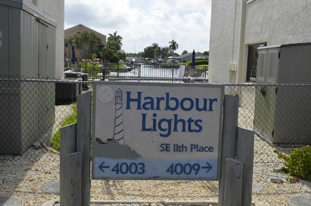 A sign for Harbour Lights SE 11th Place with arrows pointing to the left for 4003 and to the right for 4009.