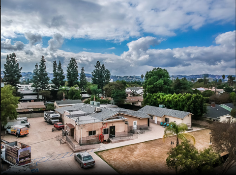 A parking lot with cars and a building in the background.