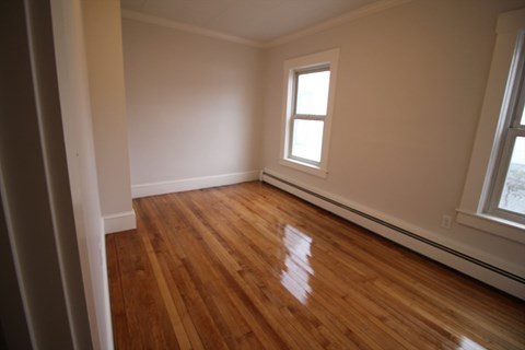 A room with wooden floors and a window.