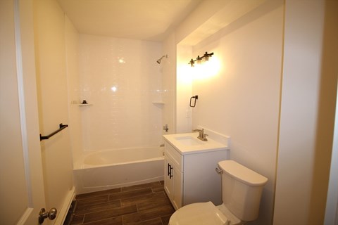 A small white bathroom with a toilet, sink and bathtub.