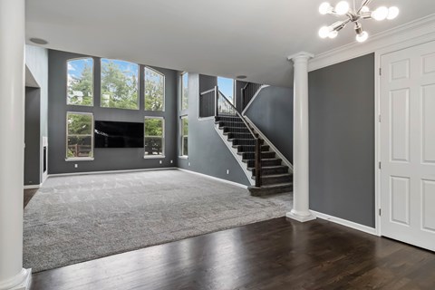 A spacious living room with a staircase leading to the upper floor.