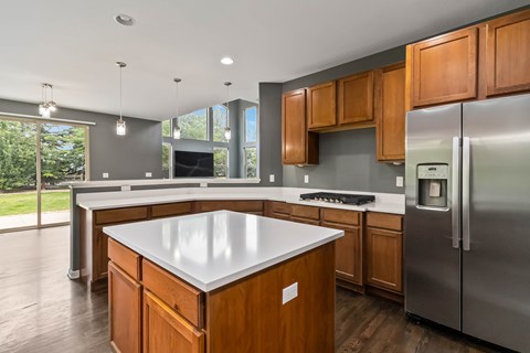 A modern kitchen with wooden cabinets and a white island.